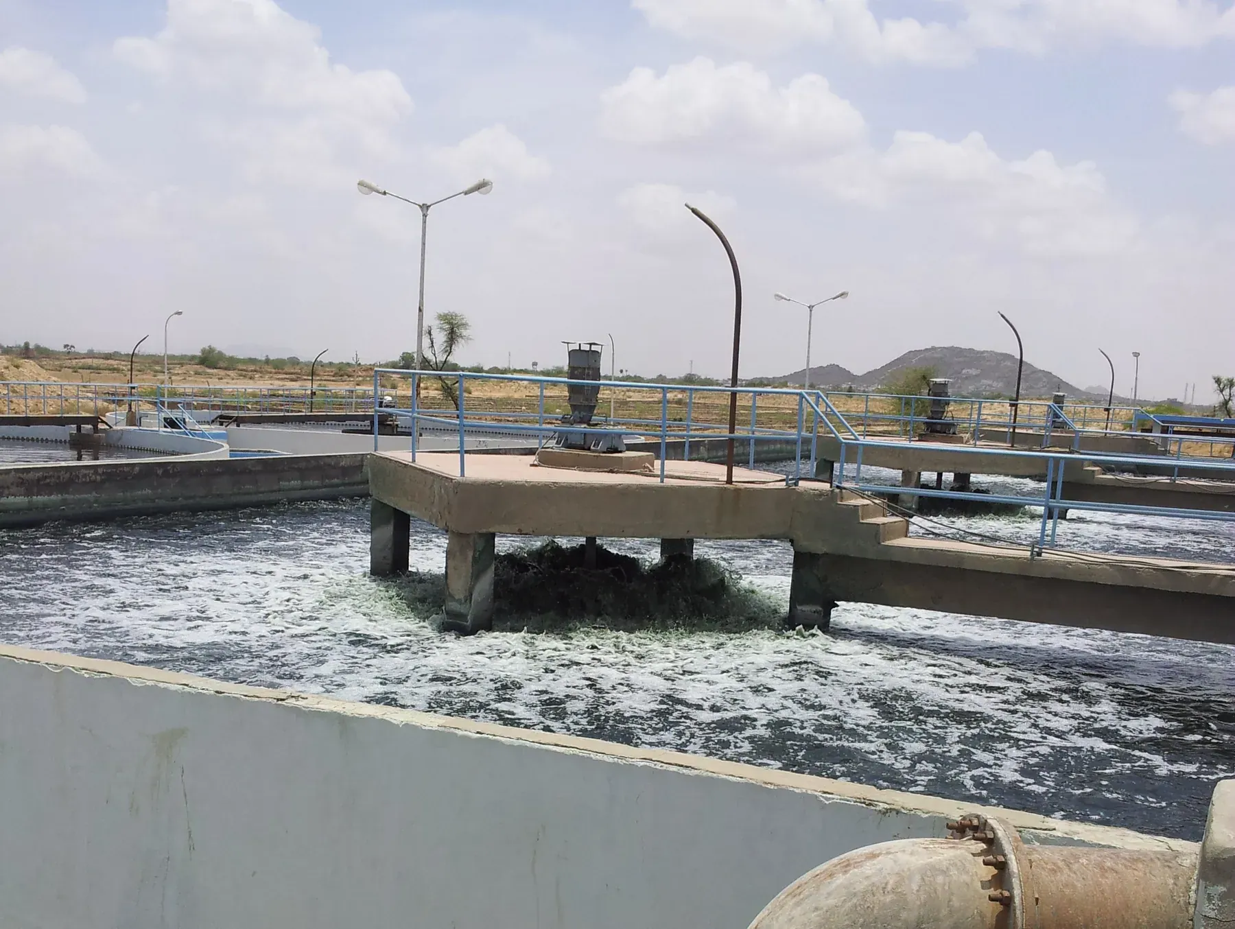 A surface aerator on a concrete platform over a working aeration basin.