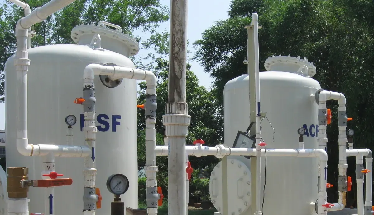 Two pressure filter vessels with valves, gauges and white pipework.